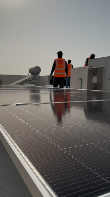 Solar panels on a villa roof with the Solar Oasis crew behind the array, Ajman