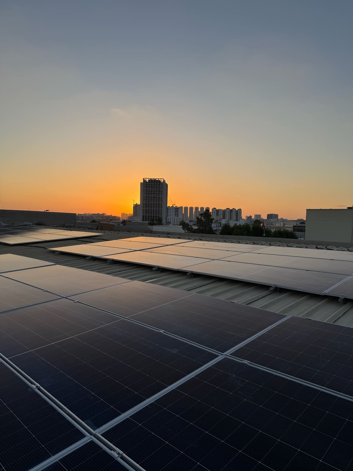 Solar array on a commercial roof at sunset, Al Jurf, Ajman