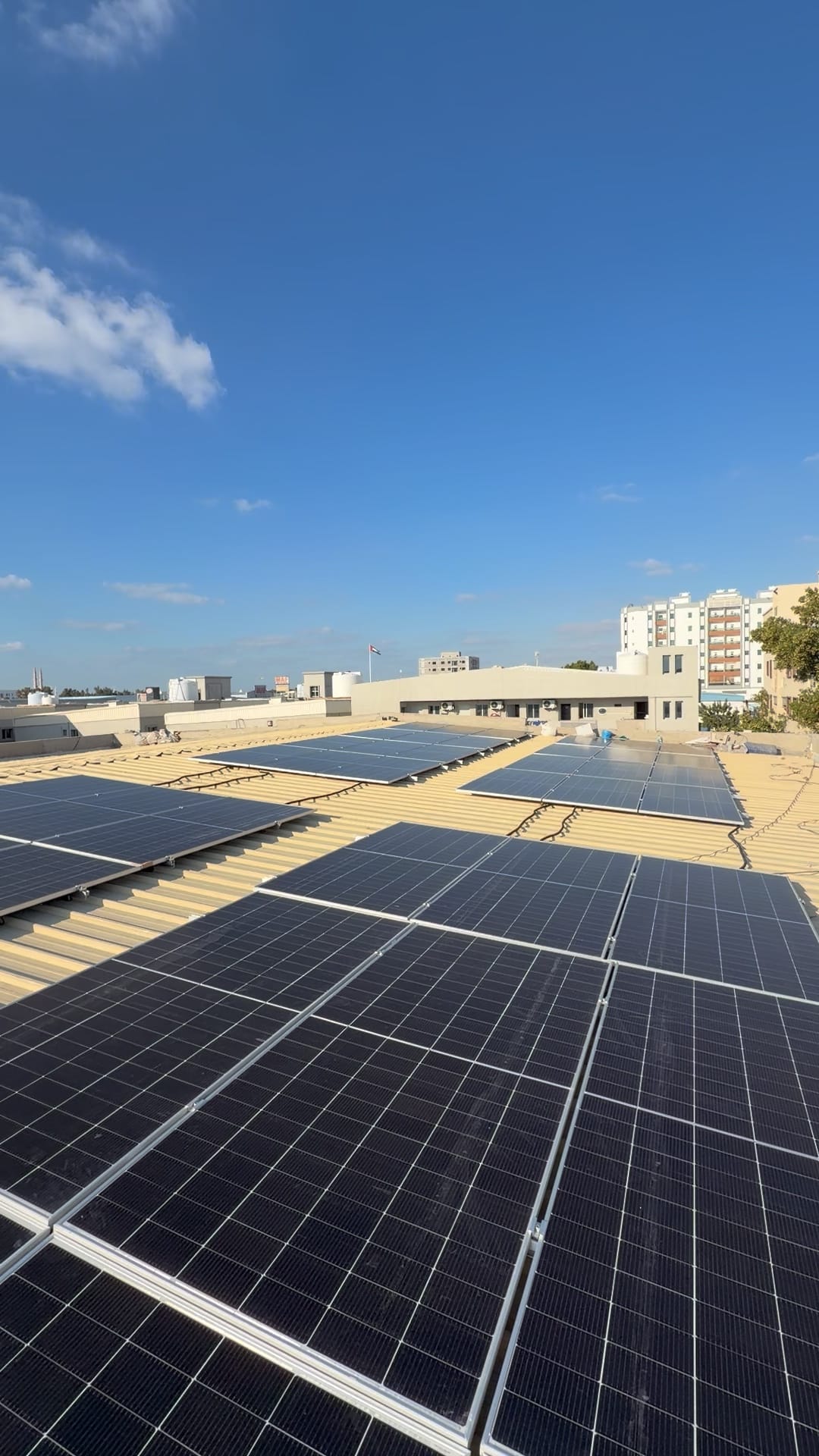 Several rows of solar panels across a metal roof in daylight, Al Jurf, Ajman
