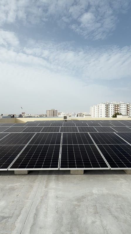 Finished solar array on a flat concrete roof under a cloudy sky, Al Jurf, Ajman
